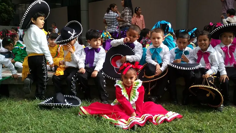 Little Hispanic girls and boys in a mariachi band.