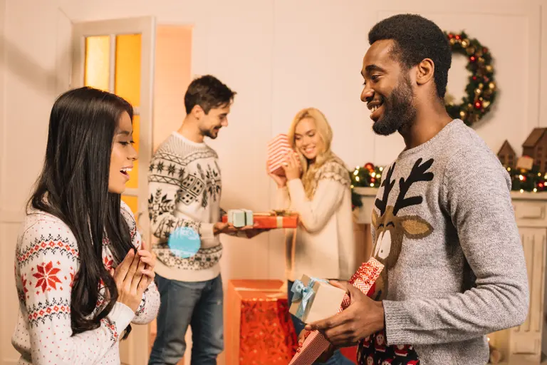Multi-ethnic young couples exchanging Christmas gifts.